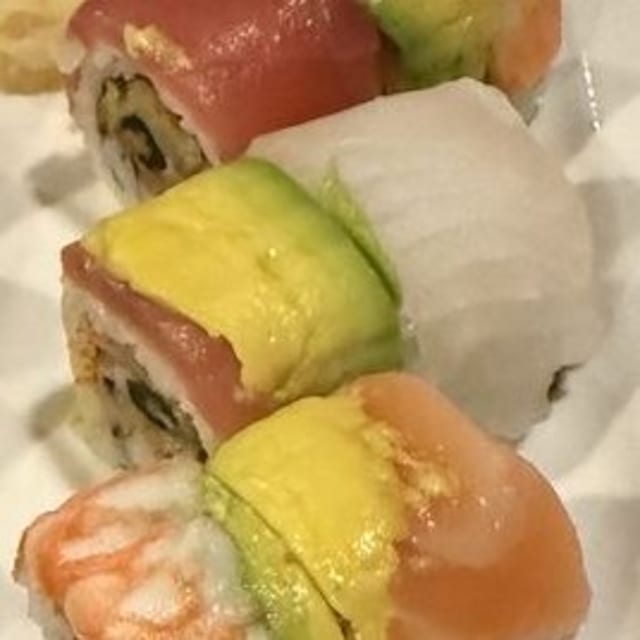 SR10. Rainbow Roll - Crab stick, avocado, cucumber with tuna, salmon, shrimp, white fish & masago outside.
